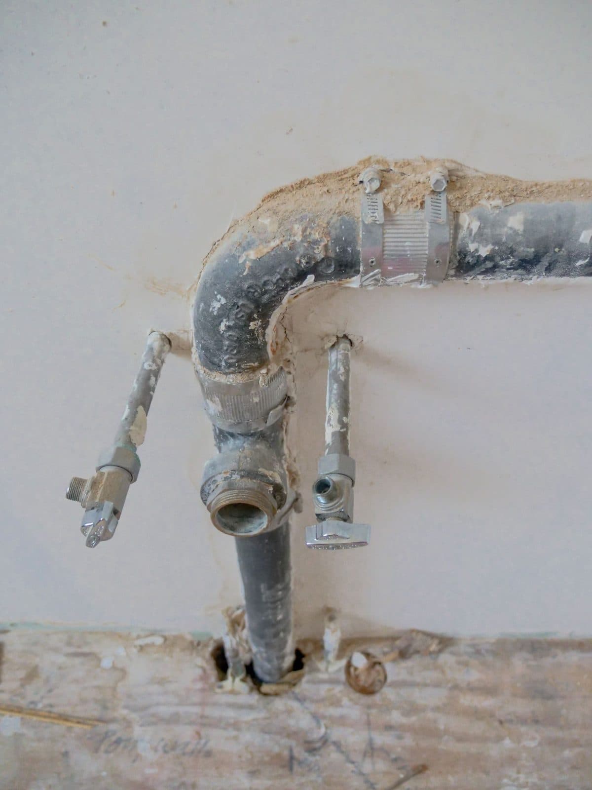 Exposed metal plumbing pipes on a wall